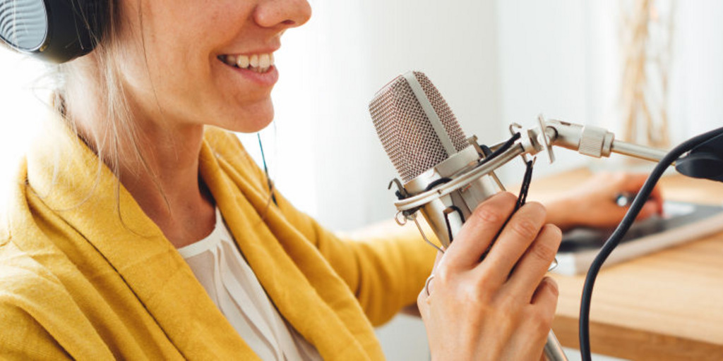 Frau spricht in ein Podcast-Mikrofon